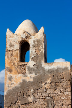 A weathered stone minaret with a domed roof rises against a clear blue sky, Tadjourah Region, Tadjoura, Djibouti
