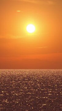 Sunset over Ocean Water Waves with Sparkling Golden Reflections Vertical View