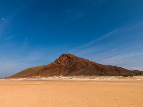 Isolated volcanic peak rises above a desert plain, Obock Region, Khor angar, Djibouti