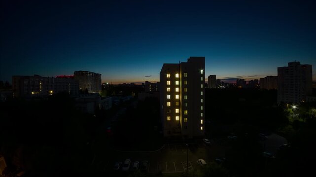 Residential apartment building at sunrise in city night-to-day transition timelapse