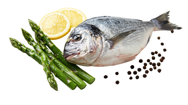 Fresh raw whole sea bream fish with green asparagus spears and lemon slices