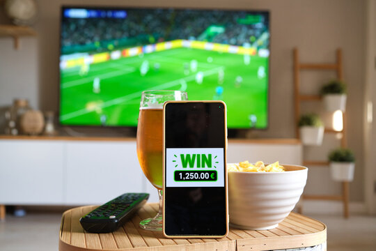 Mobile phone showing win notification watching football match