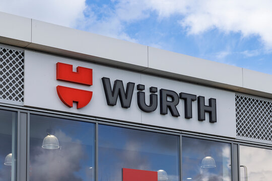 Den Bosch, Netherlands - 16 September 2026: The distinctive red and black W&uuml;rth logo displayed on the exterior facade of a commercial building against a blue sky.