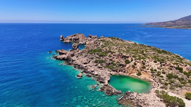 Voulolimni forms a crater like saltwater lagoon enclosed by rugged rock and a narrow sea passage near Chrysoskalitissa, Kissamos, Chania, Crete, Greece, drone parallax orbit