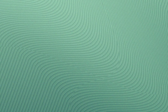 Abstract background with flowing wavy lines in a soft mint green color, creating a textured and rhythmic pattern with a sense of movement and depth