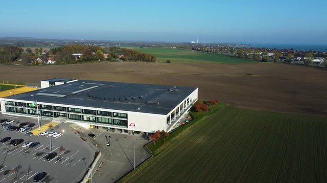 Modern commercial building surrounded by fields at Gammel Ega near Aarhus, Denmark, aerial