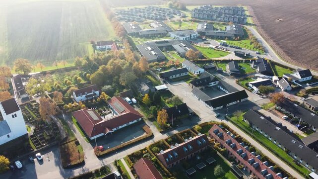 Gammel Ega church and residential neighborhood near Aarhus in warm evening light, aerial