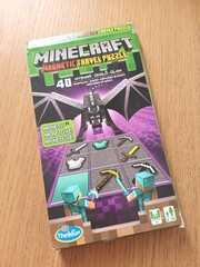 Fototapeta premium Minecraft magnetic travel puzzle game box featuring an ender dragon and pixelated game items