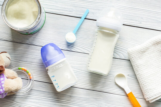 preparation of mixture baby feeding on wooden background top view