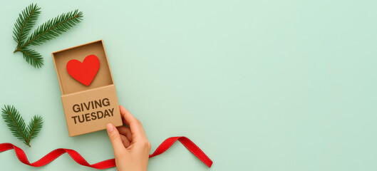 Giving Tuesday charity concept with heart, ribbon, and greenery on pastel background © dvoevnore