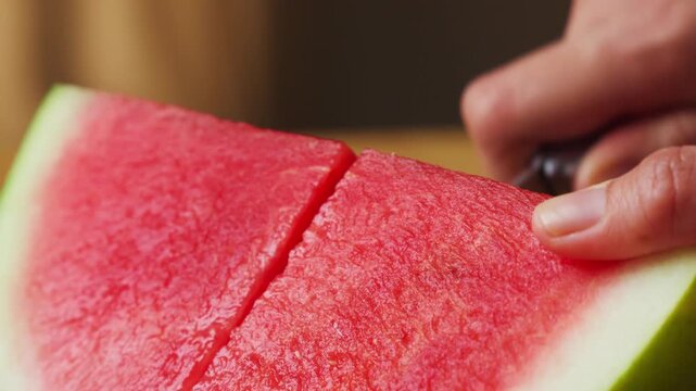 Cutting fresh watermelon into slices on a wooden cutting board