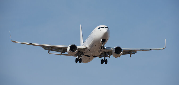 The plane lands. Airplane, passengers flying in the blue sky, preparing to land at the airport