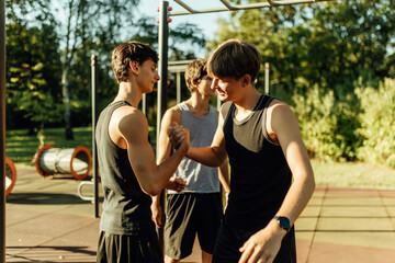 Obraz premium Teenager boys shaking hands together at the street fitness park.