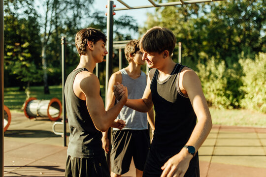 Teenager boys shaking hands together at the street fitness park.