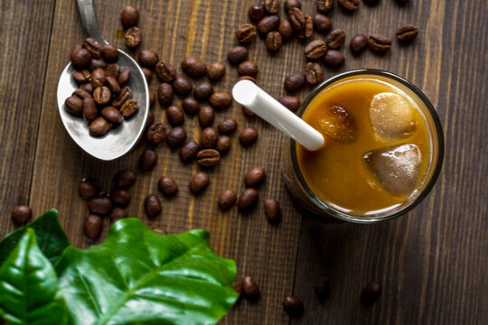 coffee with ice in glass on wooden background top view
