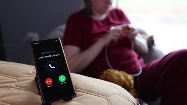 Phone showing incoming call on couch in a calm digital detox setting with slow knitting vibe
