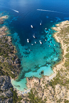 Cala Napolatana cove with boats in clear waters at la maddalena