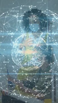 Vertical video: Woman in vest holding phone and starting torso globe, viewing nodes for safety tech