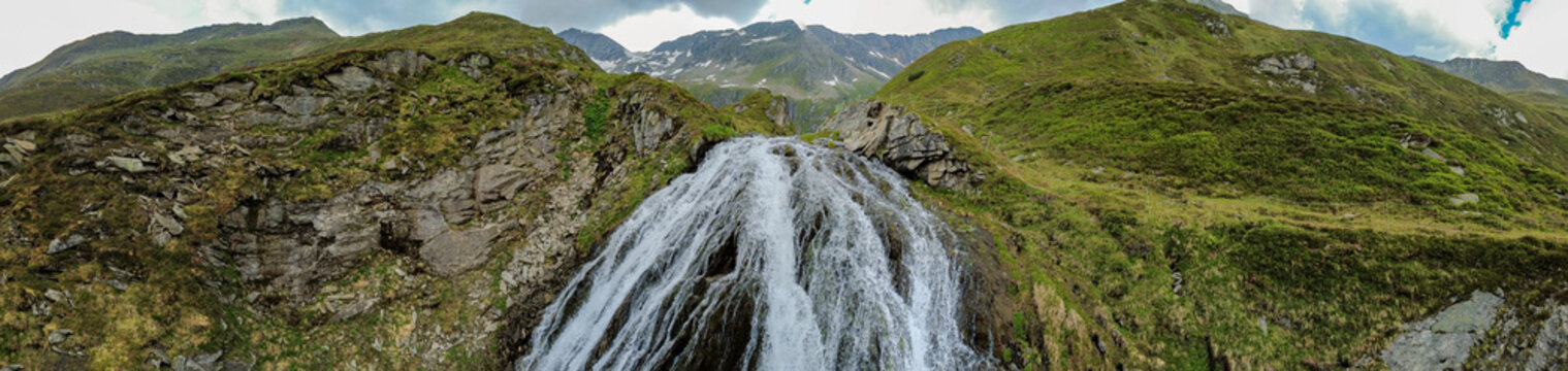 Alpine waterfall in Kitzb&uuml;hel Alps, scenic aerial view of mountain stream and wilderness in Hohe Tauern National Park in Austria