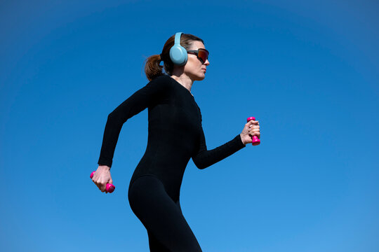 Woman in Sportswear Training with Dumbbells
