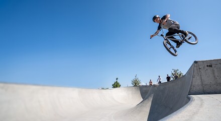 Fototapeta premium BMX Rider Performing Jump in Skatepark
