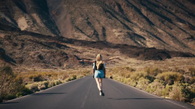 A woman running down an empty road through the dramatic volcanic landscape of Teide National Park, Tenerife, Spain, passing a parked van along the roadside.