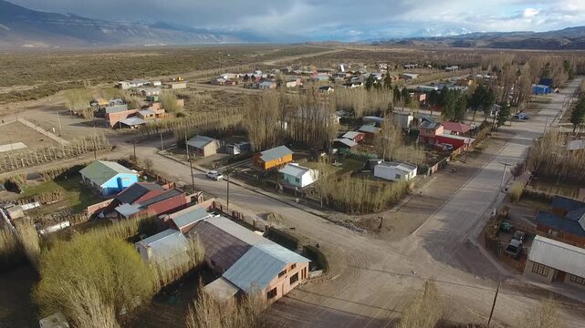 4K drone aerial view over Lago Posadas village in Santa Cruz, Argentina, revealing homes surrounded by rugged Patagonian landscapes, arid terrain and remote wilderness scenery.
