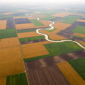 High-altitude aerial photography of farmland color patches and meandering rivers