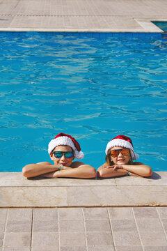 Christmas vacation on a tropical island. Children at a swimming pool at Christmas. Real people, not AI.