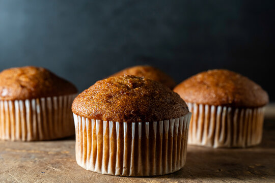 Carrot cake muffins in paper liners on a wood surface 