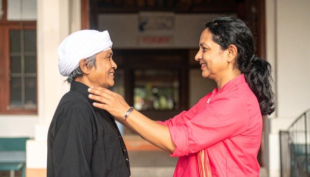 Elderly man with white turban and younger woman in pink shirt bonding