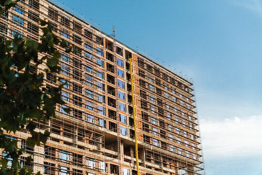 Large building is wrapped in scaffolding during construction in Belgrade. Development concept for real estate, renovation, engineering and investment.