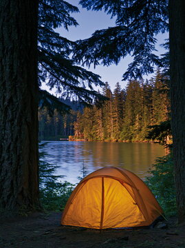 Vivid Orange Camping Tent Set Against Majestic Mountain Landscape, Inviting Outdoor Adventure and Serenity