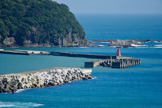 岬から見える夏の綺麗な海と赤灯台