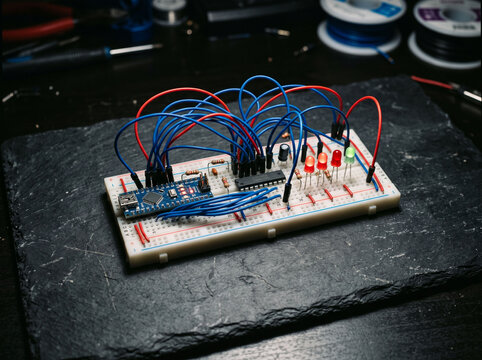 Electronic circuit breadboard with arduino board connected by red and blue jumper wires.