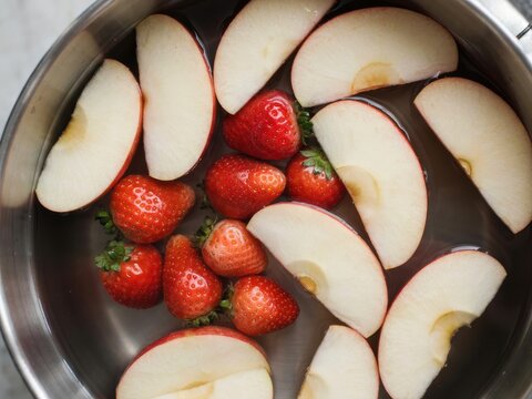 Fresh strawberries and apple slices in a pot