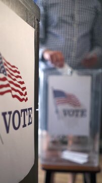 Midterm and presidential elections in USA, man voting at polling station with blurred background