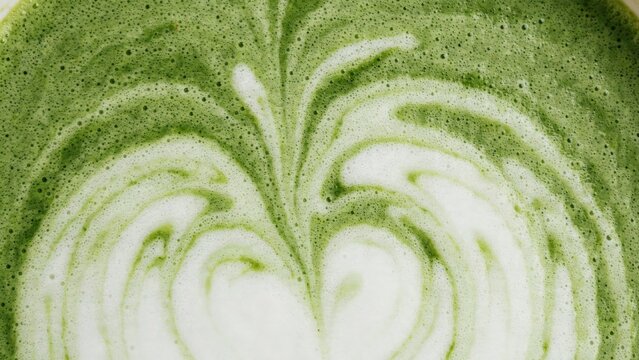 Closeup of a matcha green tea latte with artistic foam latte art design