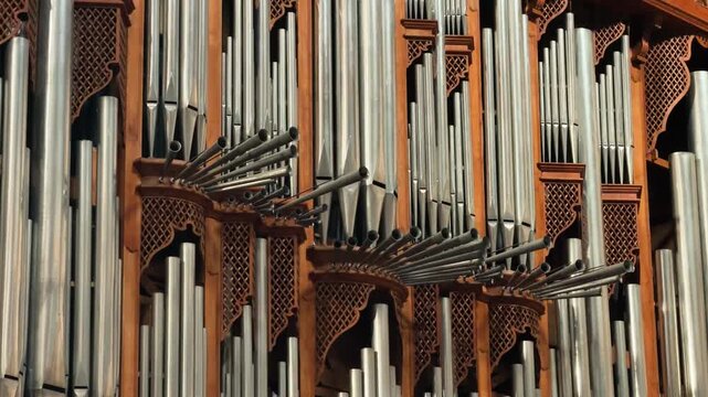 Close-up of ornate church pipe organ with metal pipes, traditional musical instrument.