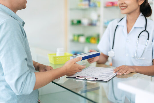 A woman hands a prescription to a doctor. The prescription is fo