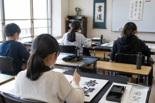 Japanese children practicing calligraphy in a traditional class
