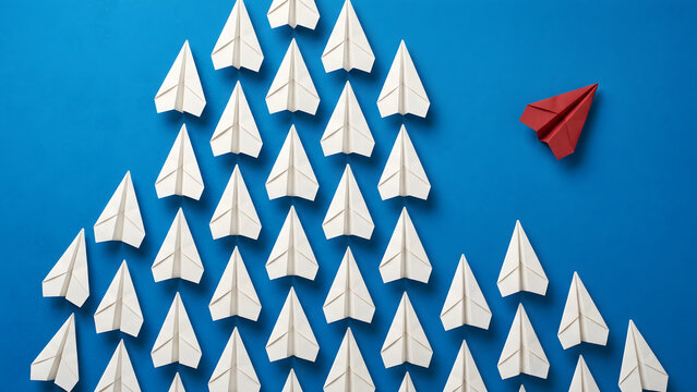 Red paper plane changing direction and standing out from white crowd representing leadership and individuality