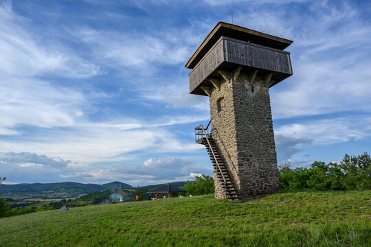 Vartovka watchtower on a green meadow hill with the valley of Krupina beyond, Slovakia