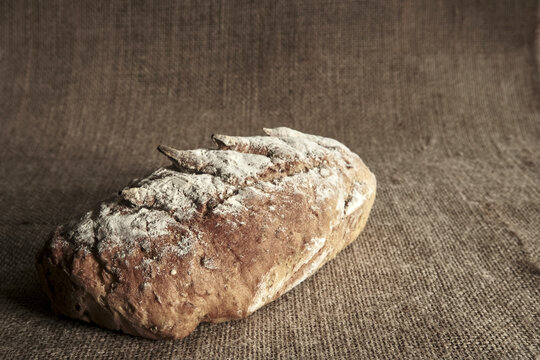 Rustic artisan wholegrain bread loaf on natural linen, symbolizing healthy, nutritious eating, traditional baking, fiber and wholesome food.