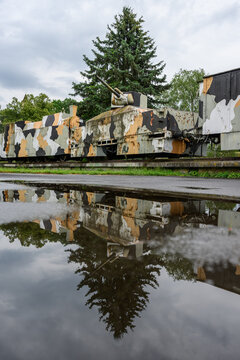 Armoured train and spruce reflected in a rain puddle after a summer shower, Zvolen, Slovakia