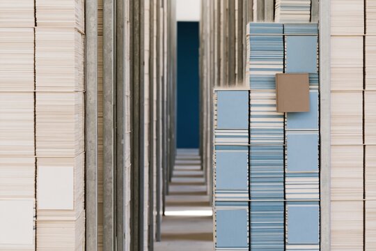 Tall columns of card tiles in a dim archive corridor, featuring dusty textures and structured layers for data and organization concepts