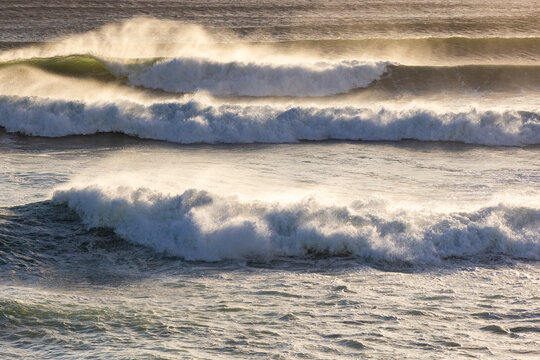 massive waves crashing into rock formations, Walker Bay Nature Reserve, South Africa at sunset