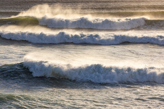 massive waves crashing into rock formations, Walker Bay Nature Reserve, South Africa at sunset