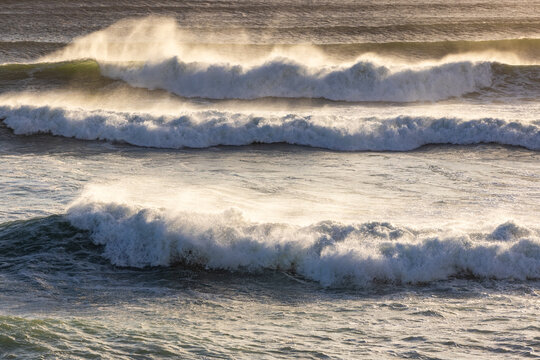 massive waves crashing into rock formations, Walker Bay Nature Reserve, South Africa at sunset