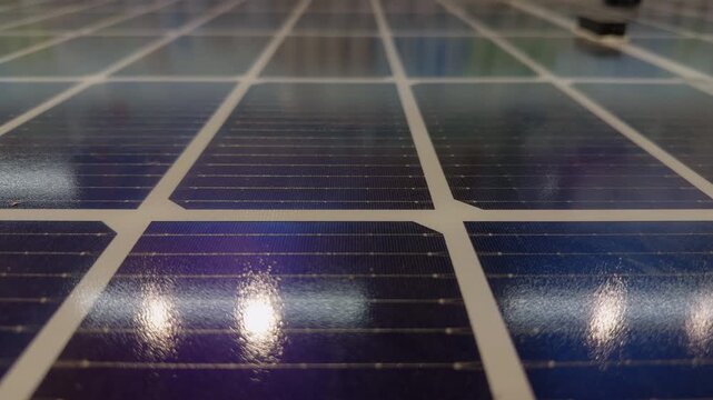 Solar Panel Cells Reflect Bright Lights in a Close Low Angle View, Supporting Renewable Energy and Clean Technology